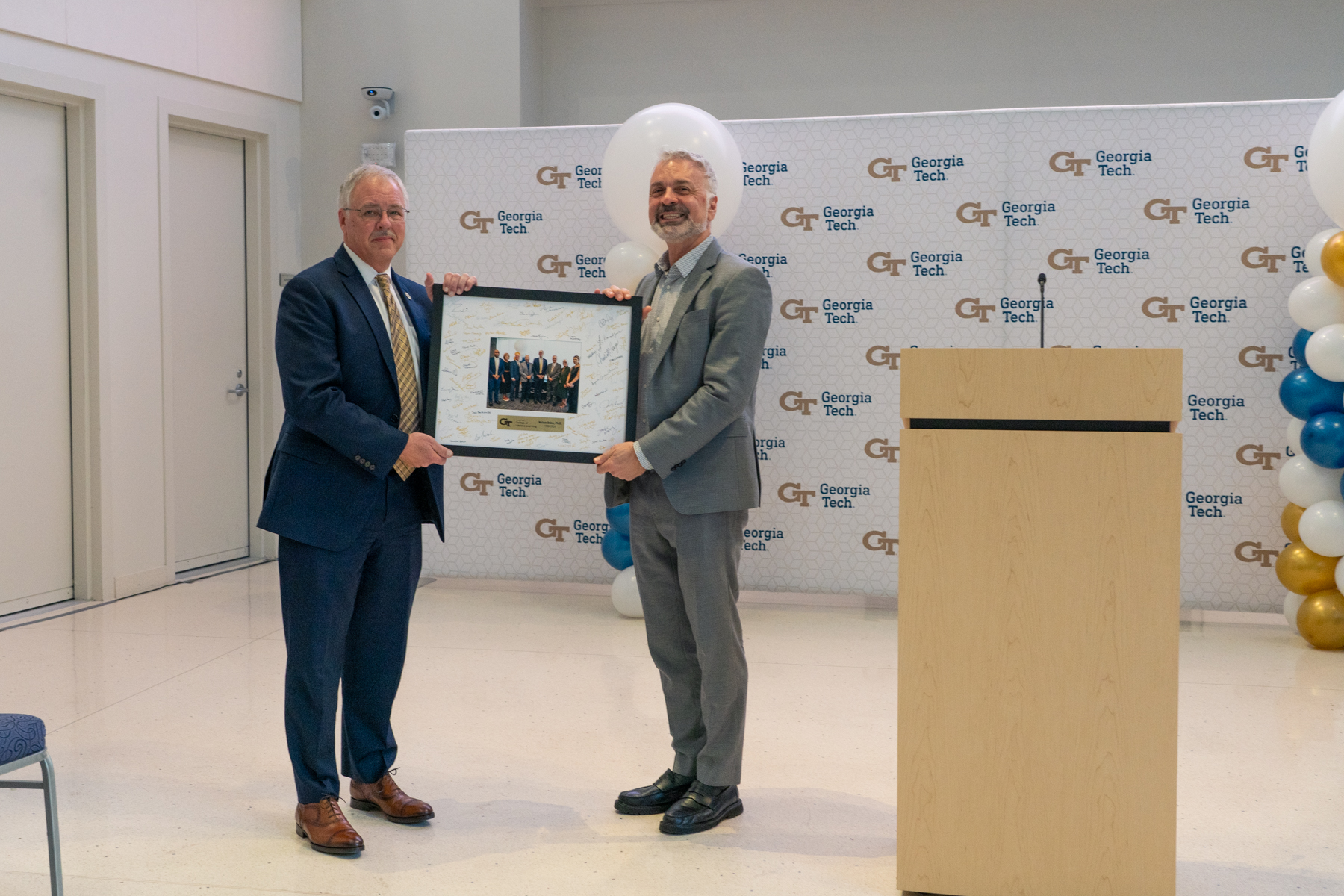 Dean Bill Gaudelli presented Nelson Baker with a signed plaque from his College of Lifetime Learning colleagues.
